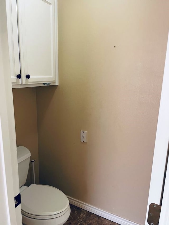 bathroom with toilet and baseboards