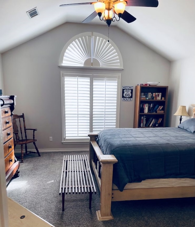 carpeted bedroom with vaulted ceiling, baseboards, visible vents, and a ceiling fan