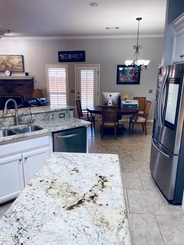 kitchen featuring white cabinets, light stone counters, ornamental molding, stainless steel appliances, and a sink