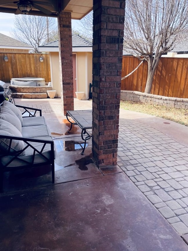 view of patio / terrace featuring a ceiling fan, a fenced backyard, and a jacuzzi