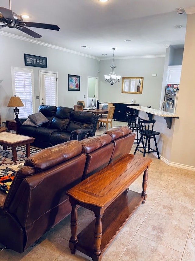 living area with ceiling fan with notable chandelier, crown molding, baseboards, and light tile patterned floors