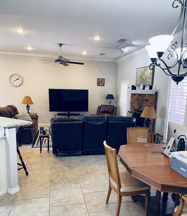 dining space with a wealth of natural light, a brick fireplace, crown molding, and light tile patterned floors