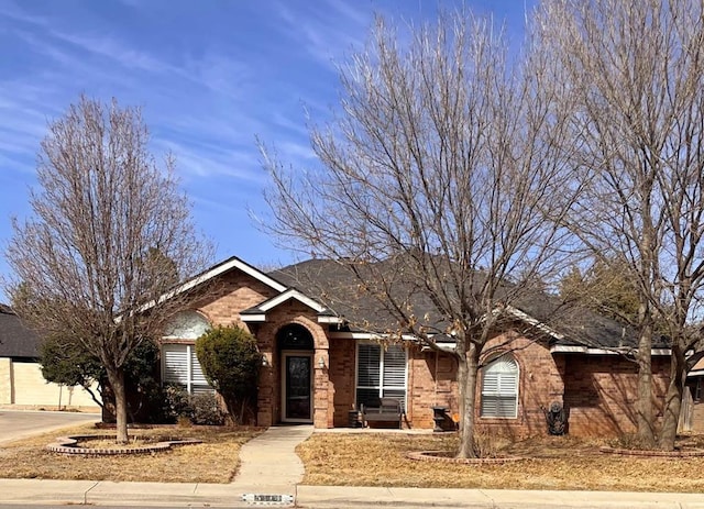 ranch-style home featuring driveway and brick siding