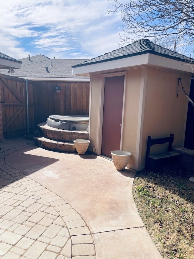 exterior space with a patio, a shingled roof, and fence