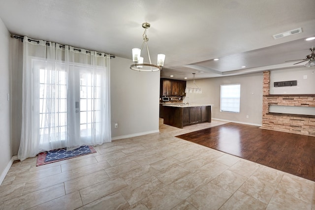 1901 College Ave, Midland, TX 79701 - unfurnished living room with baseboards, a chandelier, ceiling fan, and a sink