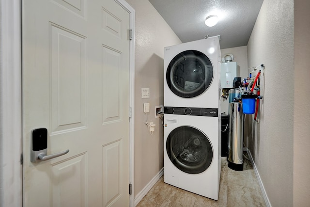 1901 College Ave, Midland, TX 79701 - laundry area with stacked washer and clothes dryer, baseboards, and a textured ceiling