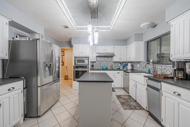2807 Ann Dr, Midland, TX 79705 - kitchen with appliances with stainless steel finishes, dark countertops, a sink, backsplash, and a center island