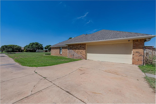 2807 Ann Dr, Midland, TX 79705 - view of property exterior featuring brick siding, a yard, roof with shingles, and an attached garage