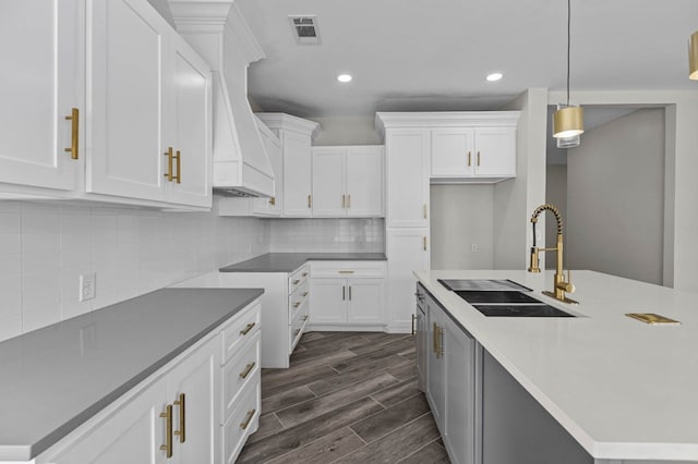 kitchen featuring sink, white cabinets, and decorative light fixtures