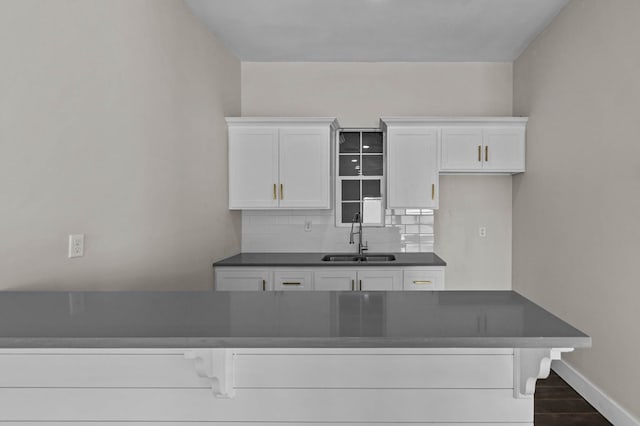 kitchen featuring backsplash, sink, white cabinets, and dark hardwood / wood-style floors