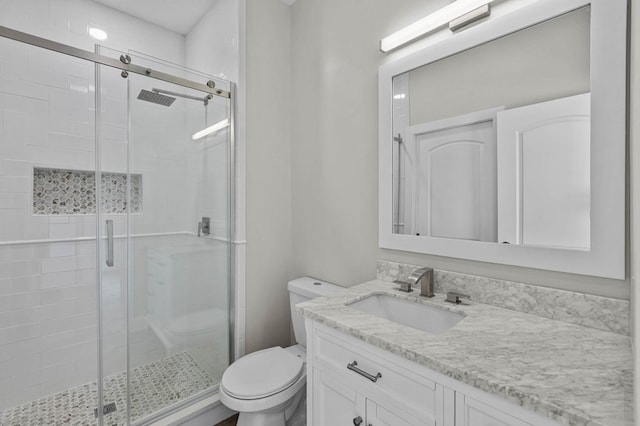 bathroom with walk in shower, vanity, and toilet