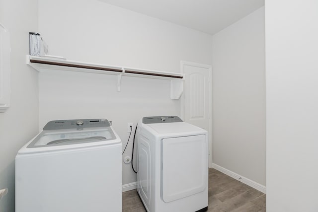 laundry area with washer and clothes dryer and light hardwood / wood-style flooring