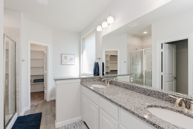 bathroom with hardwood / wood-style floors, vanity, and an enclosed shower