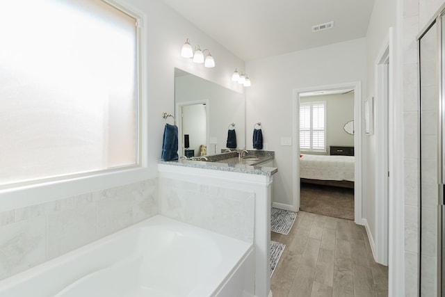 bathroom featuring vanity and a bath