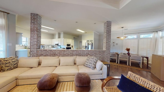 living room featuring light hardwood / wood-style floors, crown molding, and a wealth of natural light