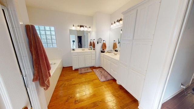 bathroom featuring hardwood / wood-style flooring, vanity, and a bathtub