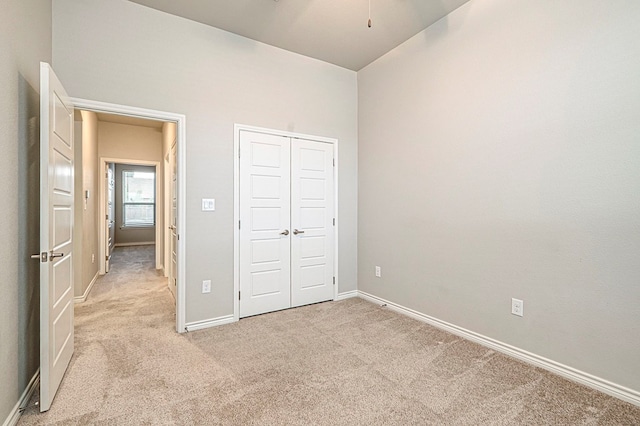 unfurnished bedroom featuring a closet and light colored carpet