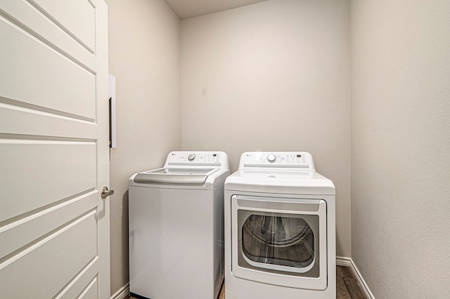 laundry room with hardwood / wood-style floors and washer and clothes dryer