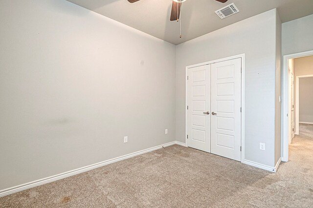 unfurnished bedroom with ceiling fan, a closet, and light colored carpet