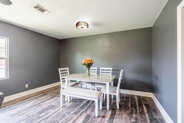 702 Dellwood St, Midland, TX 79701 - dining area featuring wood finished floors, baseboards, and a textured ceiling