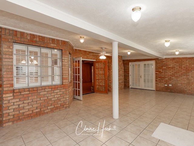 3307 Stanolind Ct, Midland, TX 79707 - unfurnished room featuring brick wall, a textured ceiling, tile patterned floors, french doors, and ornate columns