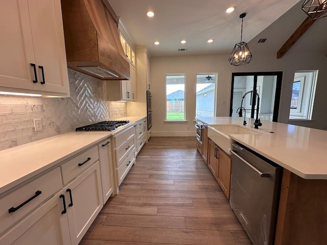 kitchen featuring custom range hood, stainless steel appliances, and white cabinetry