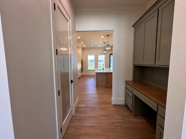 corridor featuring dark wood-type flooring, a notable chandelier, and sink