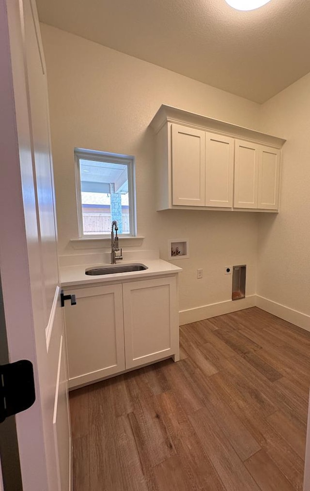 laundry room featuring cabinets, hookup for a washing machine, dark hardwood / wood-style flooring, electric dryer hookup, and sink