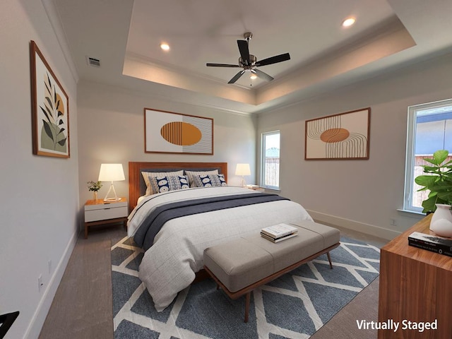 bedroom with a raised ceiling and ceiling fan