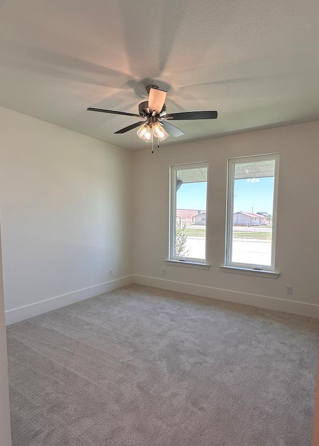 unfurnished room with ceiling fan and light carpet