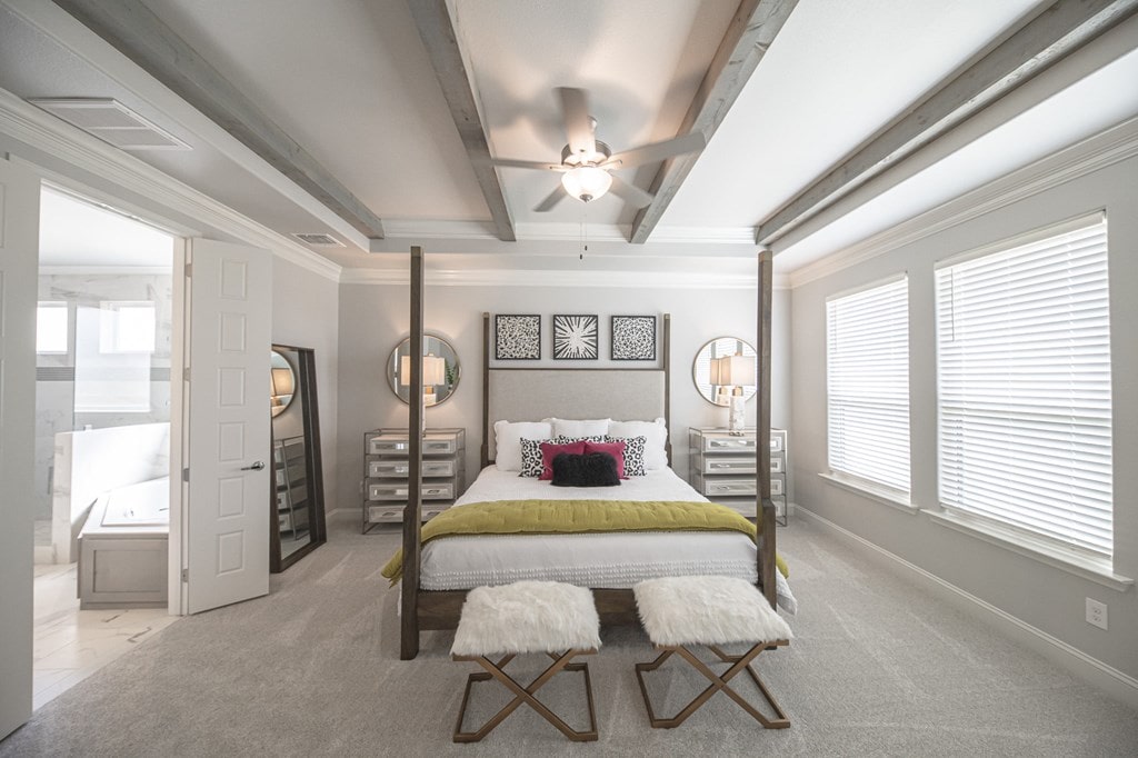 carpeted bedroom featuring beam ceiling, multiple windows, crown molding, and ceiling fan