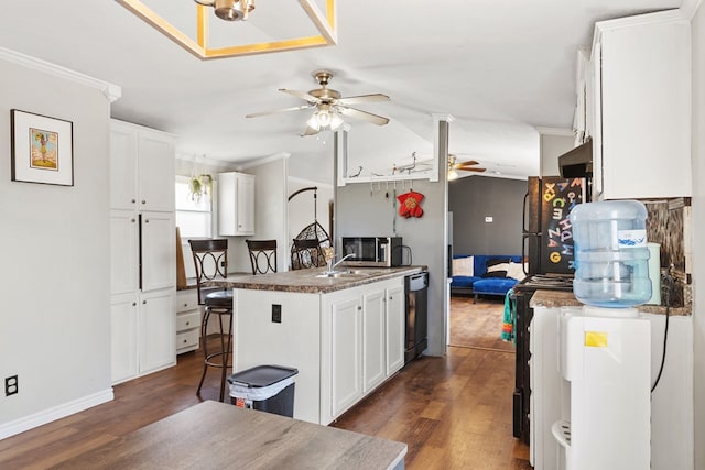 kitchen with black appliances, ceiling fan, dark wood finished floors, and crown molding