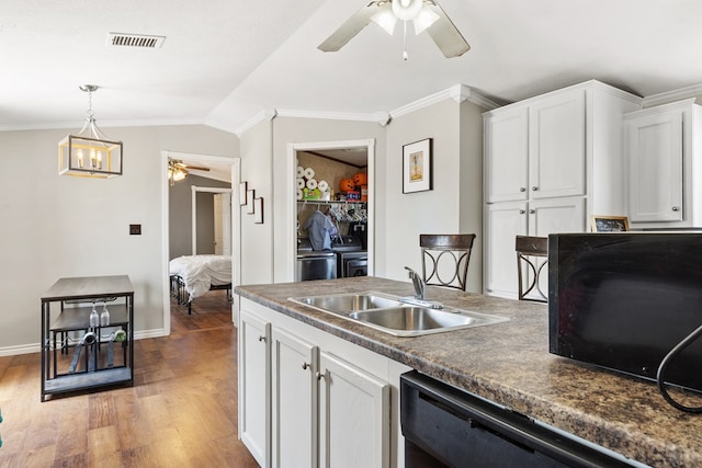 kitchen with dark countertops, visible vents, a ceiling fan, a sink, and black appliances