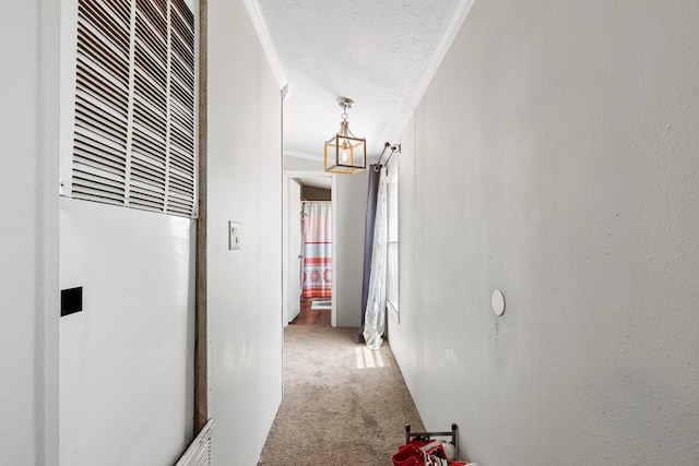 corridor featuring a textured ceiling, a textured wall, carpet floors, a heating unit, and crown molding