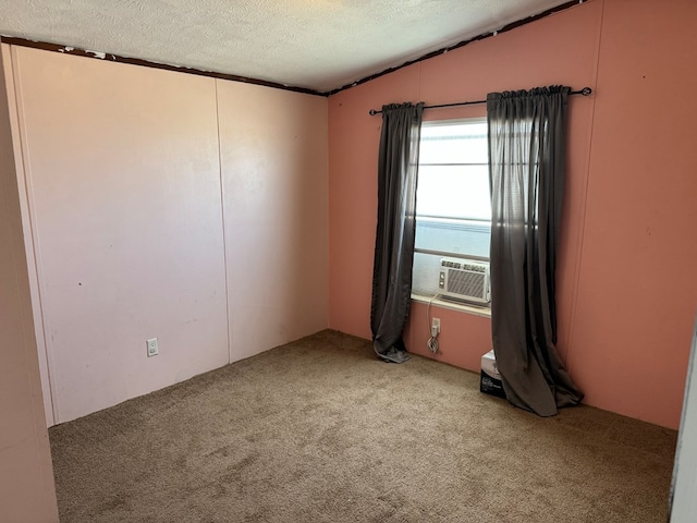 carpeted empty room with cooling unit, vaulted ceiling, and a textured ceiling