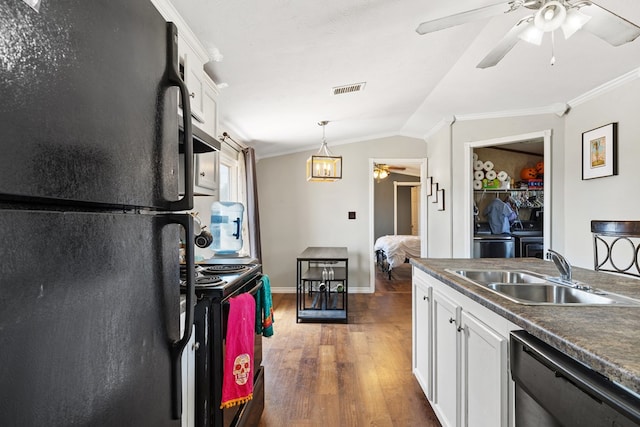 kitchen featuring a sink, visible vents, vaulted ceiling, ornamental molding, and black appliances