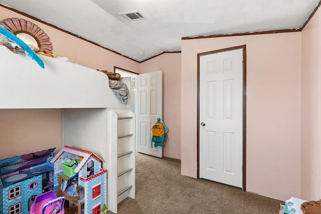 carpeted bedroom with visible vents, vaulted ceiling, and a textured ceiling