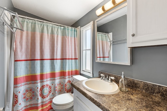 bathroom featuring a shower with curtain, vanity, and toilet