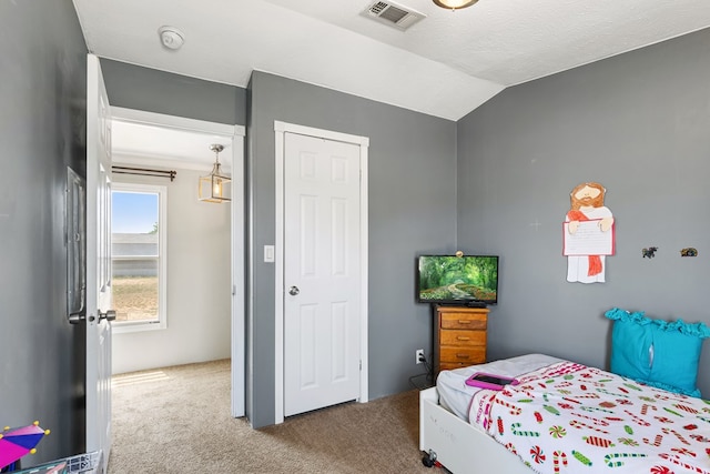 carpeted bedroom featuring lofted ceiling and visible vents