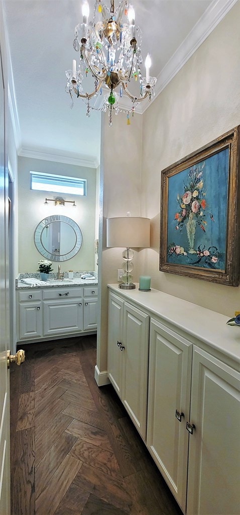 bathroom featuring vanity, a chandelier, parquet floors, and ornamental molding