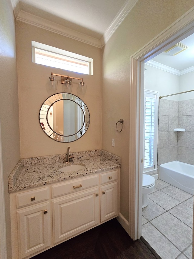 full bathroom featuring toilet, tiled shower / bath combo, vanity, and plenty of natural light