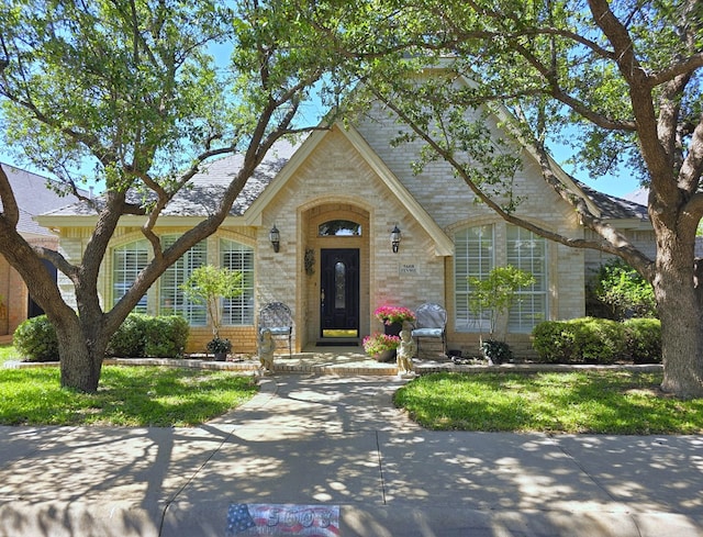 english style home featuring a front lawn