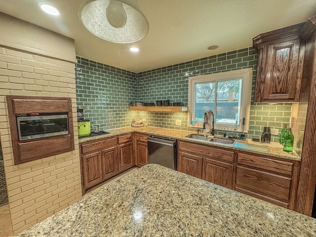 kitchen with tasteful backsplash, sink, stainless steel dishwasher, and light stone counters