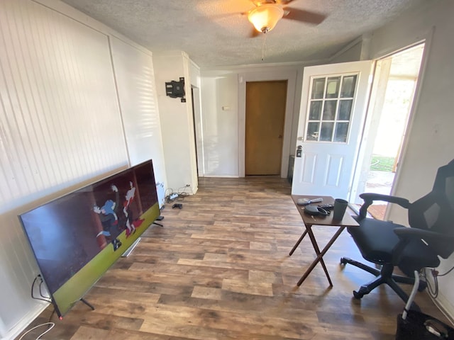 interior space featuring a textured ceiling, ceiling fan, and dark wood-type flooring