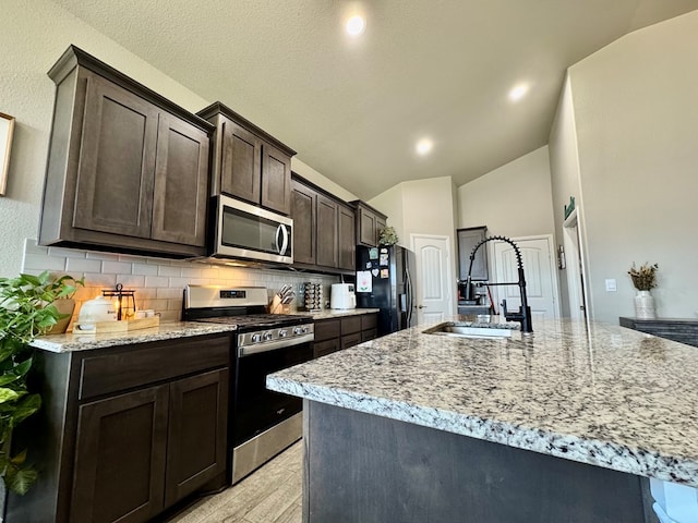 6005 Scaled Quail Rd, Midland, TX 79707 - kitchen featuring stainless steel appliances, a sink, decorative backsplash, lofted ceiling, and dark brown cabinets