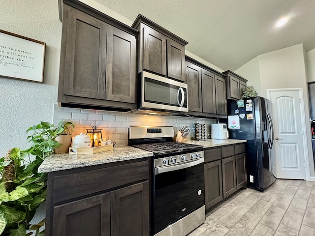 6005 Scaled Quail Rd, Midland, TX 79707 - kitchen featuring appliances with stainless steel finishes, backsplash, dark brown cabinetry, a textured wall, and lofted ceiling