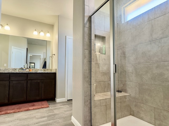 6005 Scaled Quail Rd, Midland, TX 79707 - full bath with wood finished floors, a shower stall, vanity, and baseboards
