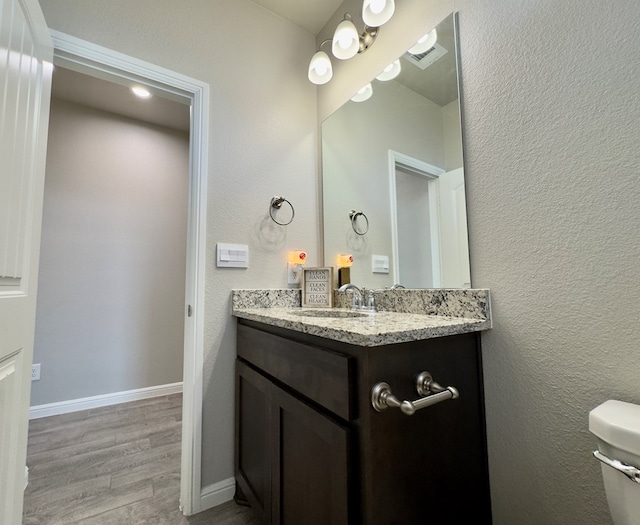 6005 Scaled Quail Rd, Midland, TX 79707 - bathroom with wood finished floors, vanity, toilet, and baseboards