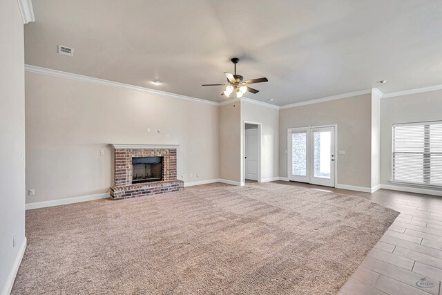 unfurnished living room featuring a fireplace, light carpet, ceiling fan, and ornamental molding