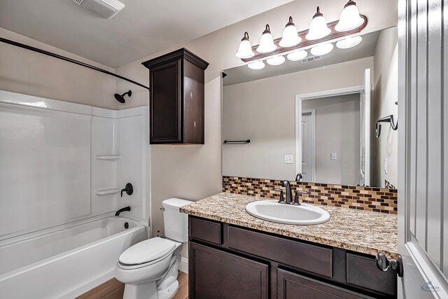 full bathroom with backsplash, vanity, wood-type flooring, washtub / shower combination, and toilet